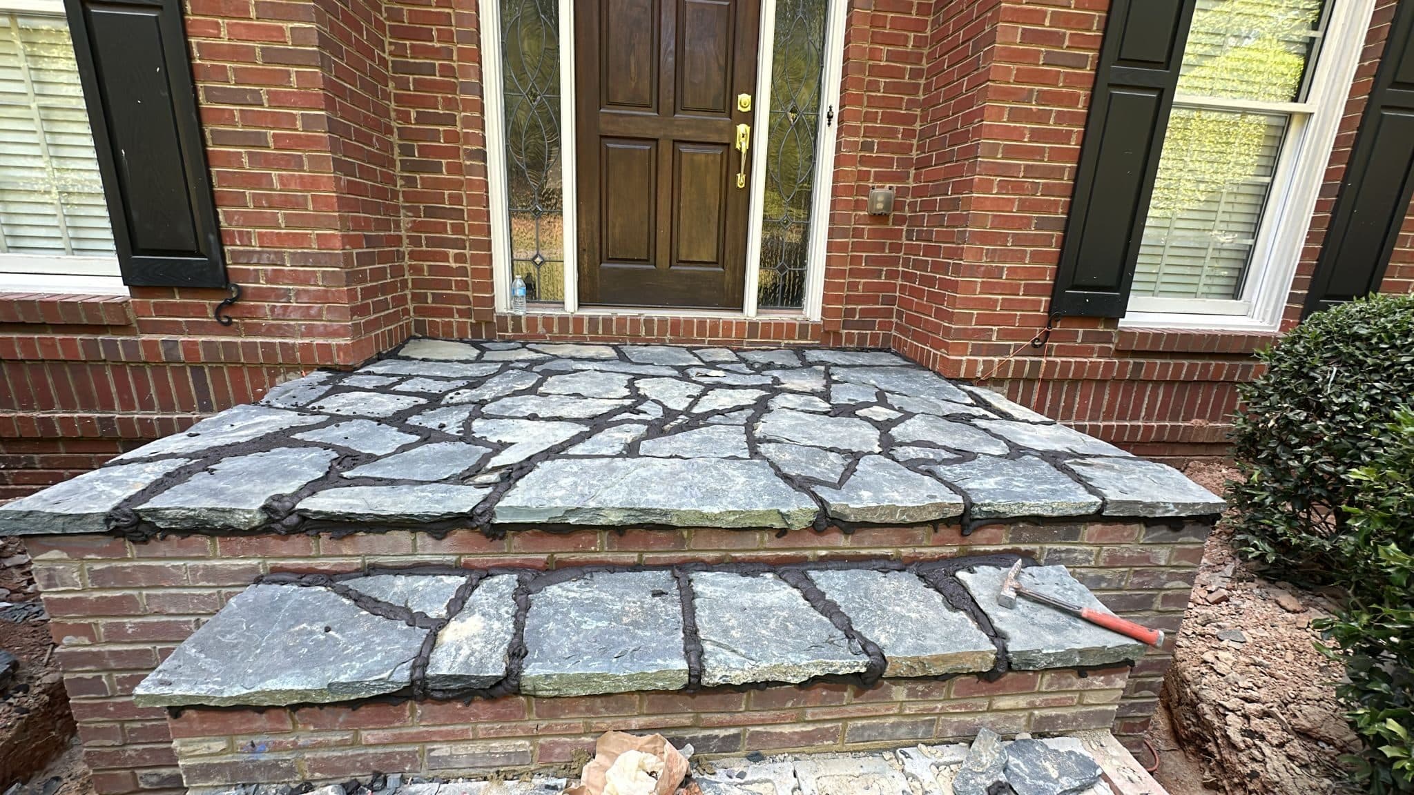 Flagstone steps and landing over brick at a front door